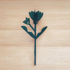 Fiore in legno verde scuro, calendula, su piano in legno chiaro, BECCA