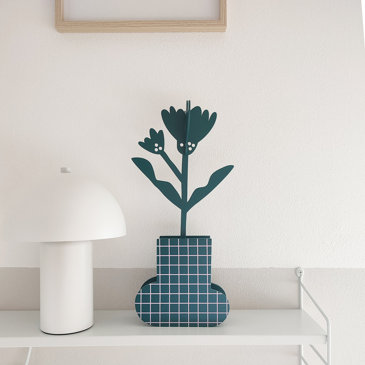 Fiore marigold in vaso in legno verde a quadretti rosa, su mensola, con lampada bianca, BECCA