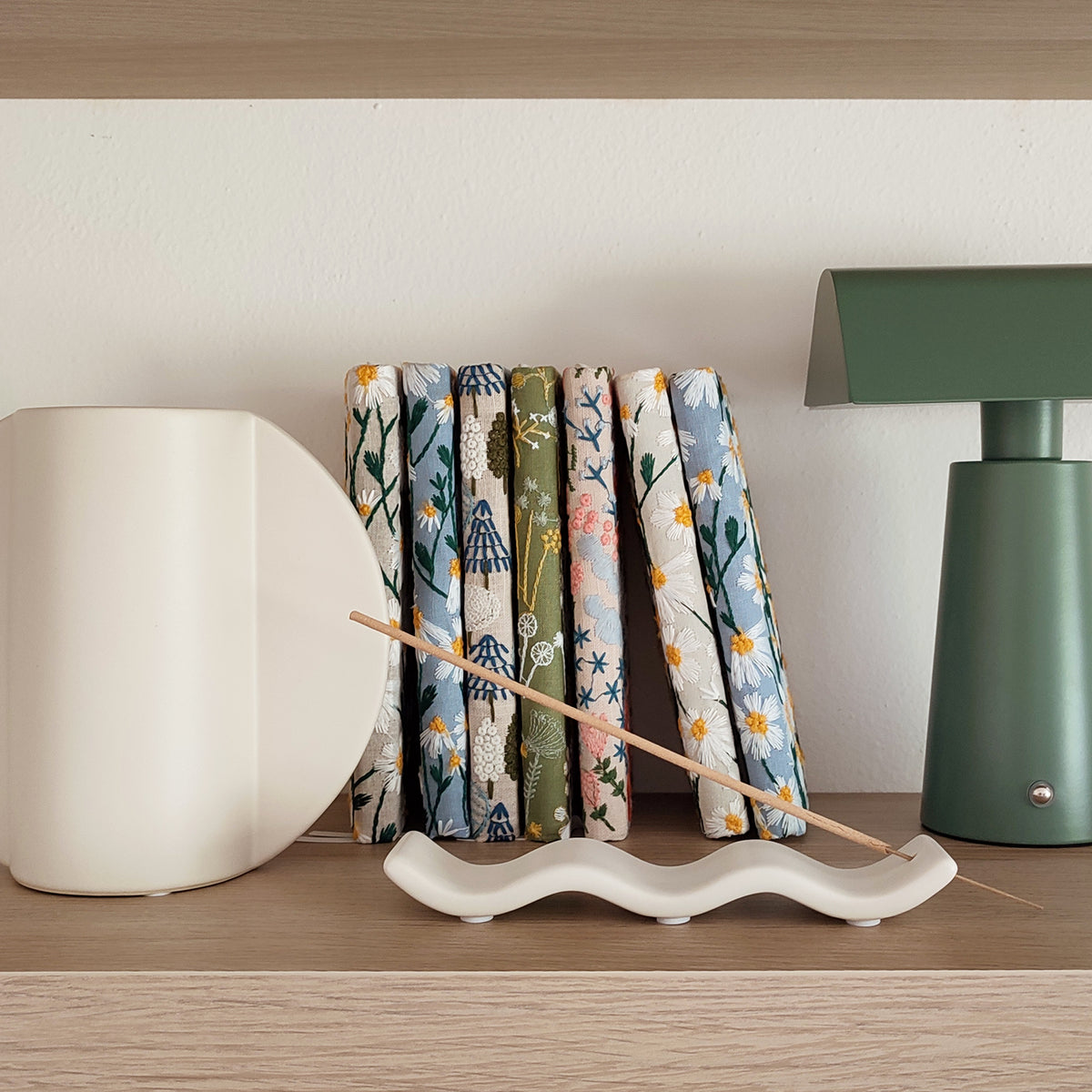 Porta incenso Wave, bianco, con incenso, ambientato su ripiano di legno, BECCA