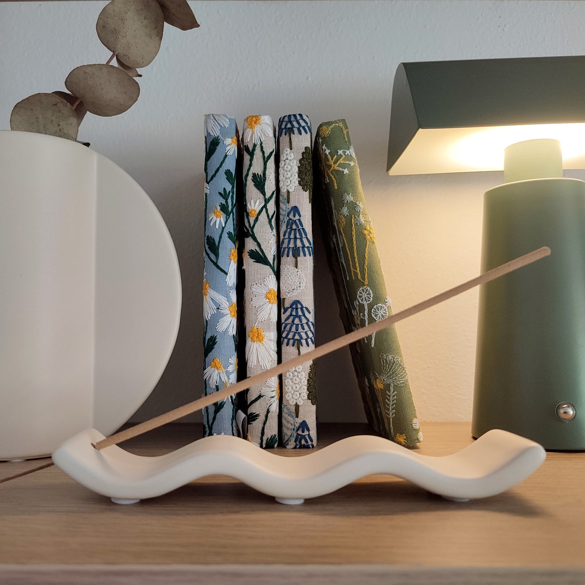 Porta incenso Wave, vista laterale, su ripiano di legno