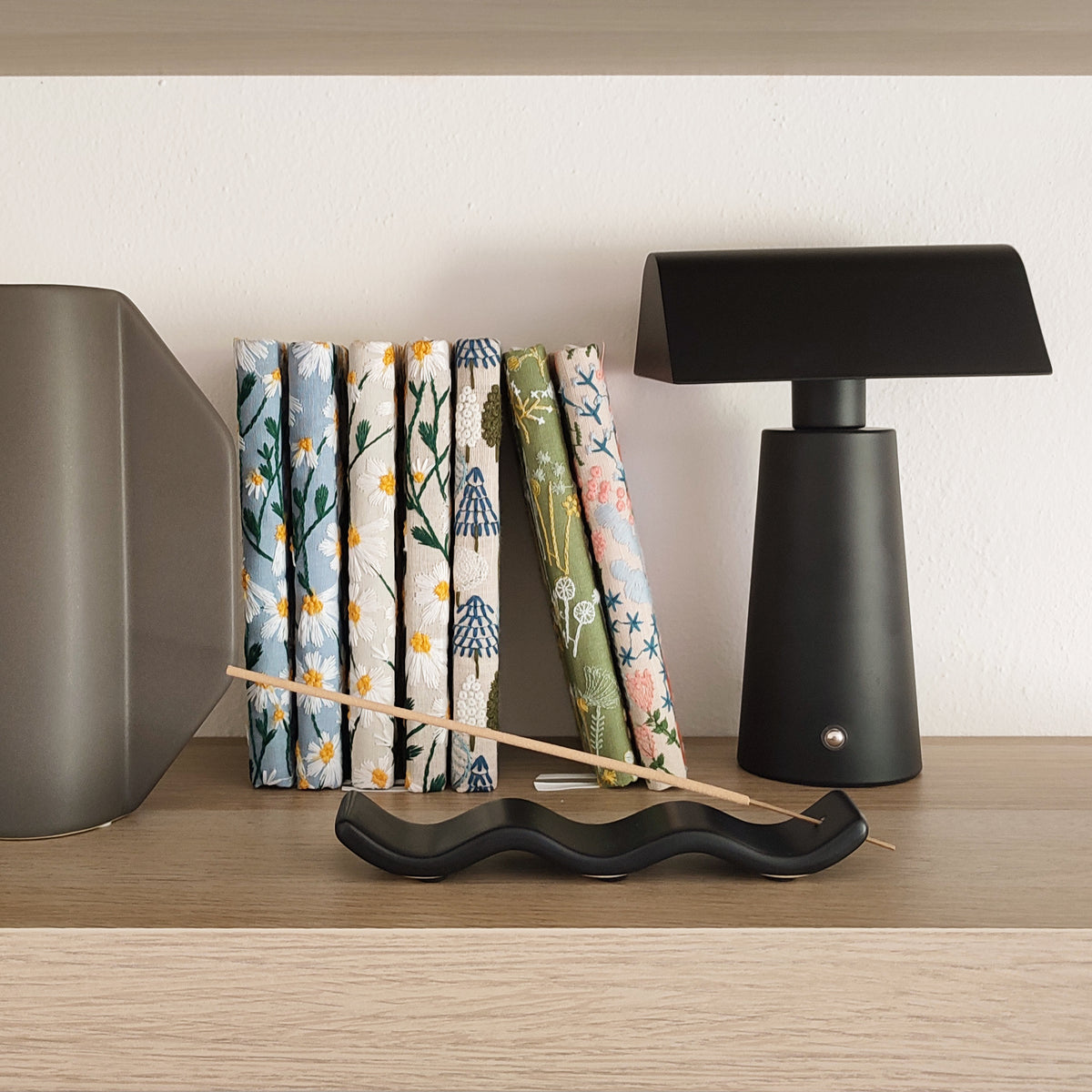 Porta incenso, nero, con incenso, su ripiano di legno, con quaderni, lampada a led e vaso grigio, becca