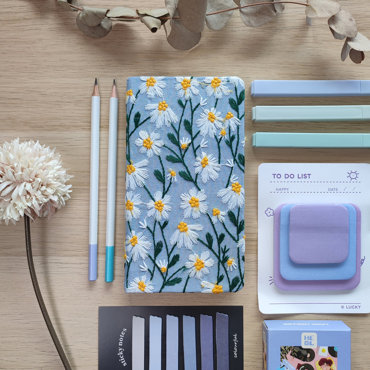Quaderno Dery, copertina margherite ricamate, azzurro, su scrivania in legno, matite post-it puzzle, BECCA