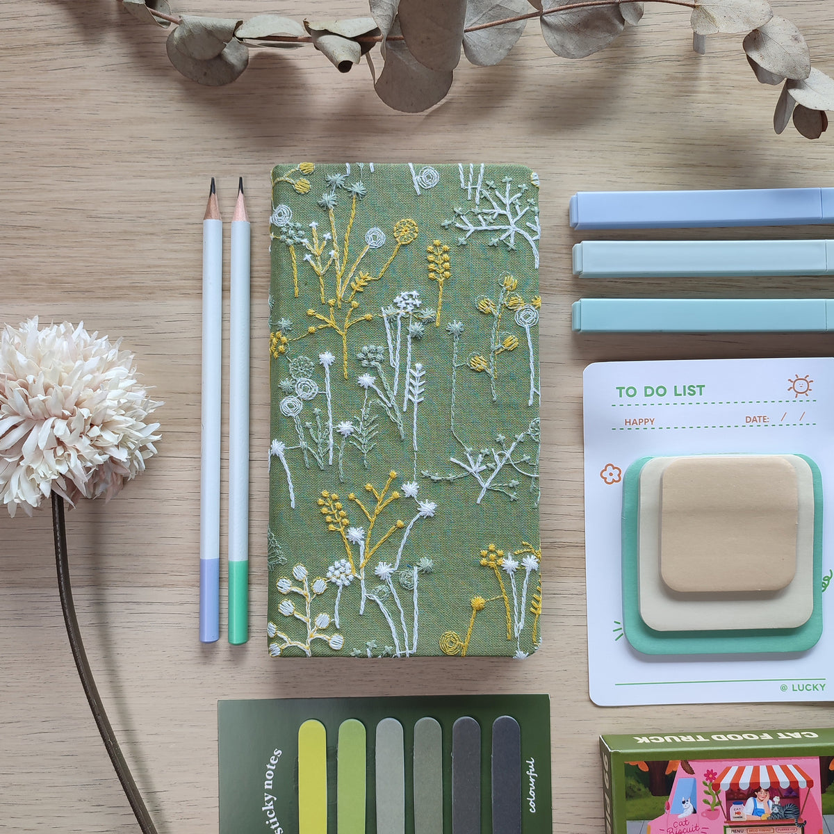 Quaderno Dery copertina rigida ricamata, verde, su scrivania in legno, matite post-it evidenziatori fiore, BECCA