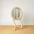 Specchio da tavolo RORRI beige, vista semi frontale, con base a forma ondulata