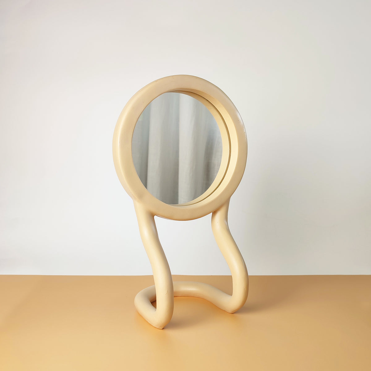 Specchio da tavolo RORRI beige, vista semi frontale, con base a forma ondulata