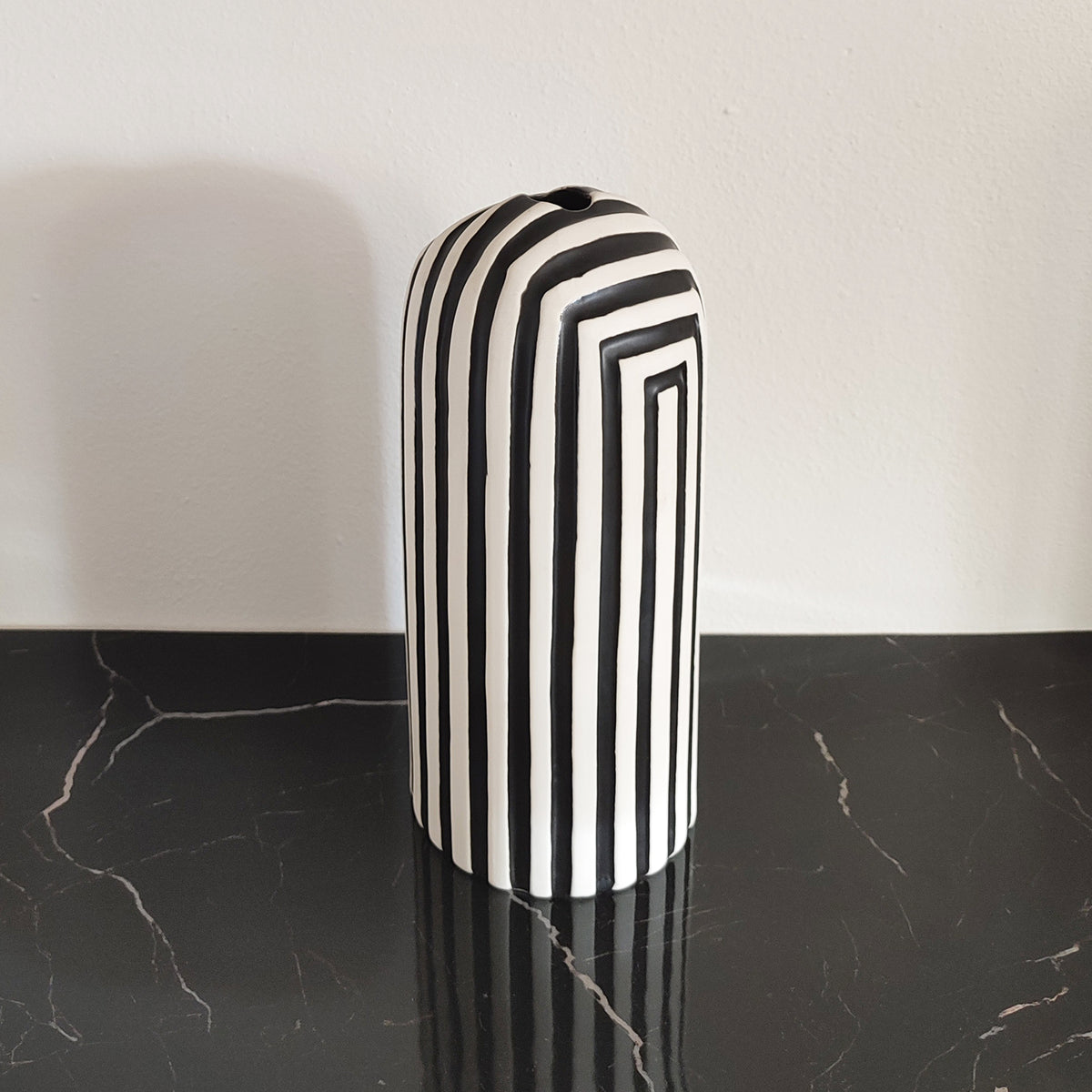 Vaso in ceramica, Black & White, scanalature nere, su ripiano in marmo nero, BECCA