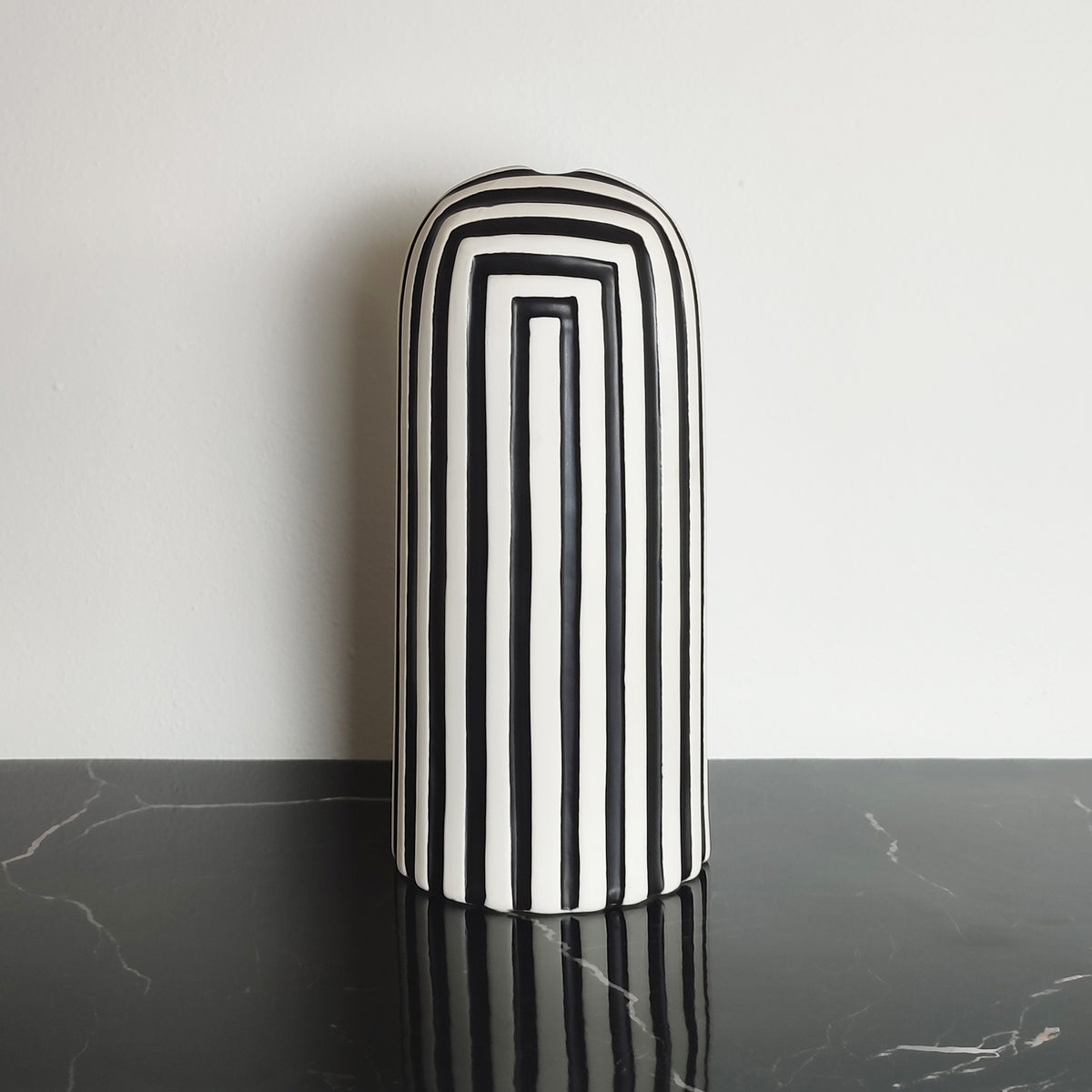 Vaso in ceramica opaca Black & White, vista frontale su ripiano nero, BECCA