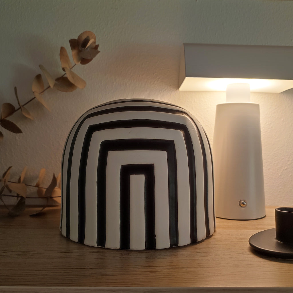 Vaso in ceramica bianco e nero, su ripiano in legno, luce soffusa, lampada bianca, fiori secchi, BECCA