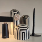 Vasi Black&White, serie in ceramica bianco e nero, su mobile chiaro, con lampada nera e portacandela nero, fiore bianco, BECCA