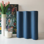Vaso Onda blu, in ceramica, su mobile bianco, con fiori candela e libro botanico, BECCA
