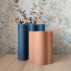 Vaso Onda, variante terracotta e blu, con fiori secchi, su ripiano in legno, sfondo floreale, BECCA