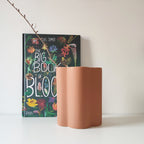 Vaso Onda, color terracotta, con ramo, su ripiano con libro botanico, BECCA