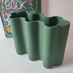 Vaso Onda verde bosco, in ceramica, dettaglio apertura superiore, su mobile chiaro con libro fiori, BECCA