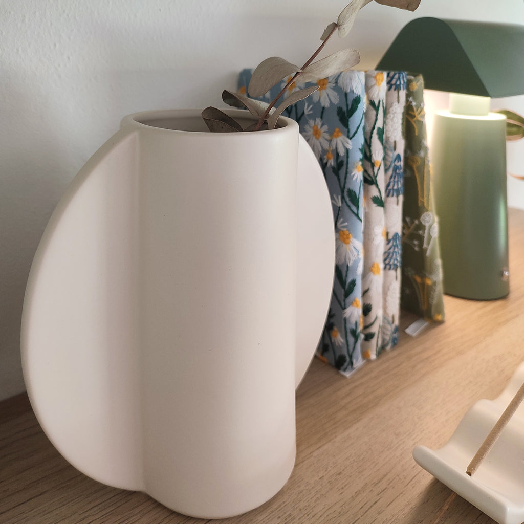 Vaso TOO POT bianco in contesto libreria in legno con libri e oggetti decorativi, BECCA