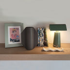 Vaso TOO POT grigio su mensola con cornice, libri e lampada verde, stile minimal, BECCA
