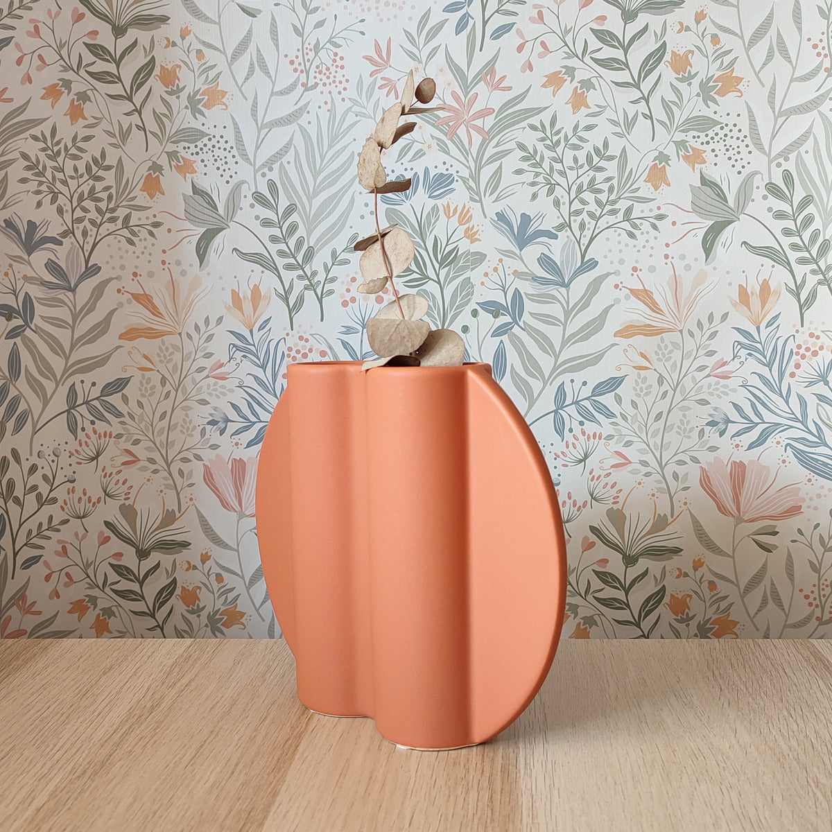 Vaso Too Pot, color terracotta, vista laterale, sfondo floreale, con eucalipto, BECCA