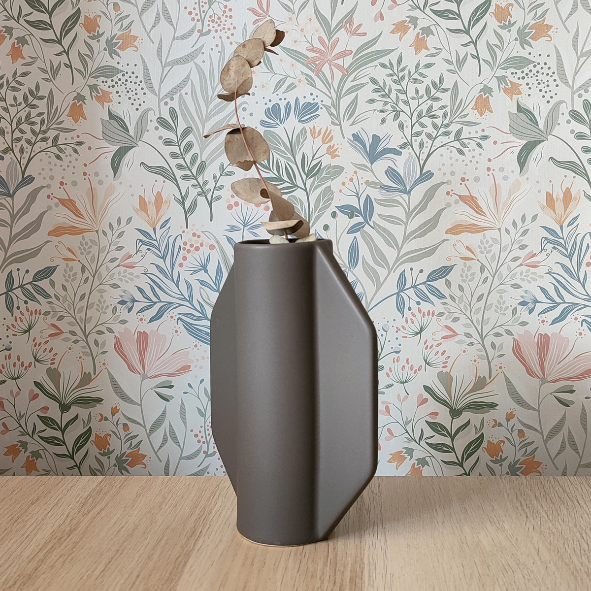 Vaso TOO POT grigio con ramo di eucalipto secco su sfondo carta da parati floreale, BECCA
