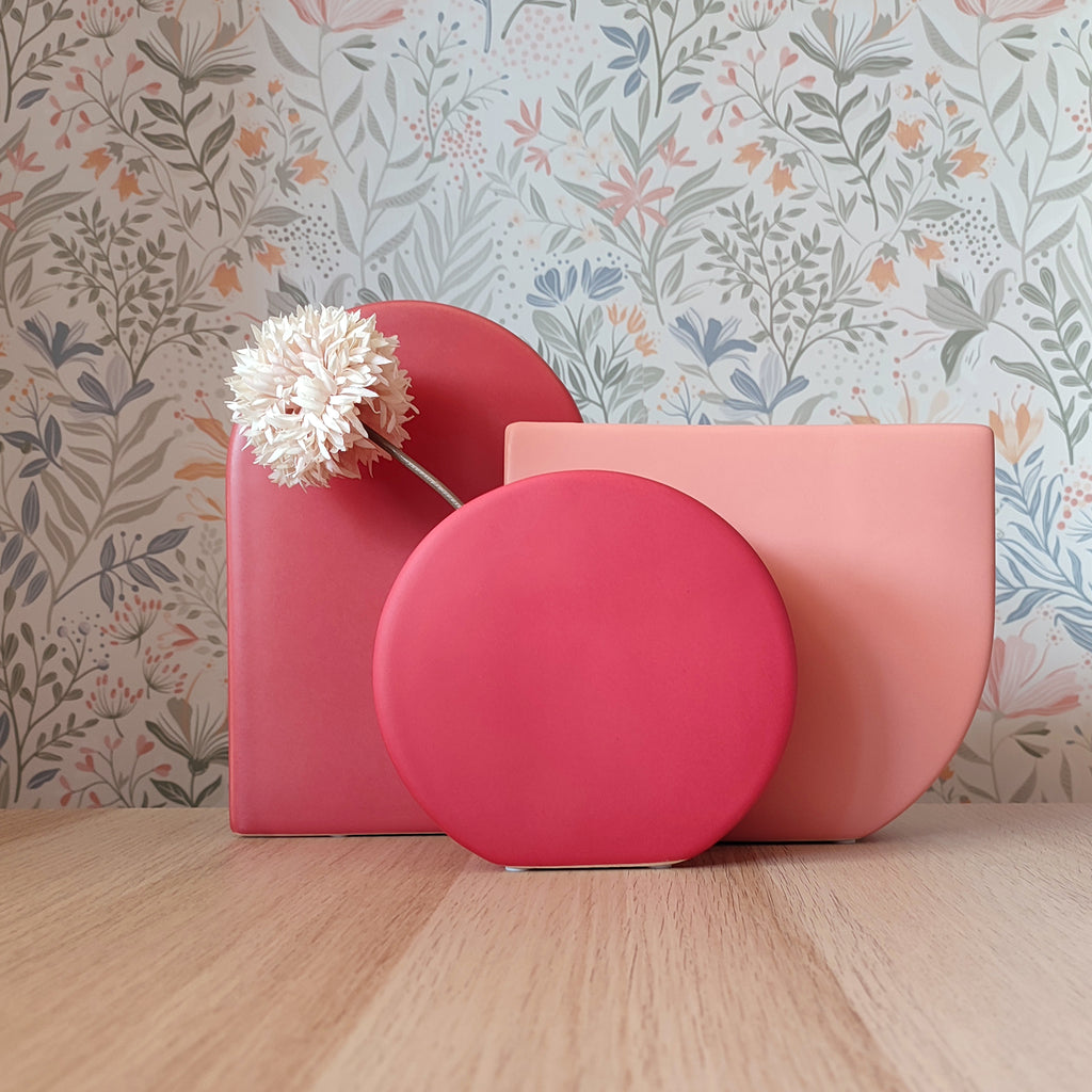 Collezione vasi BERRY taglia S, M e L in tonalità rosa, rosso e lampone su piano in legno con sfondo floreale, BECCA