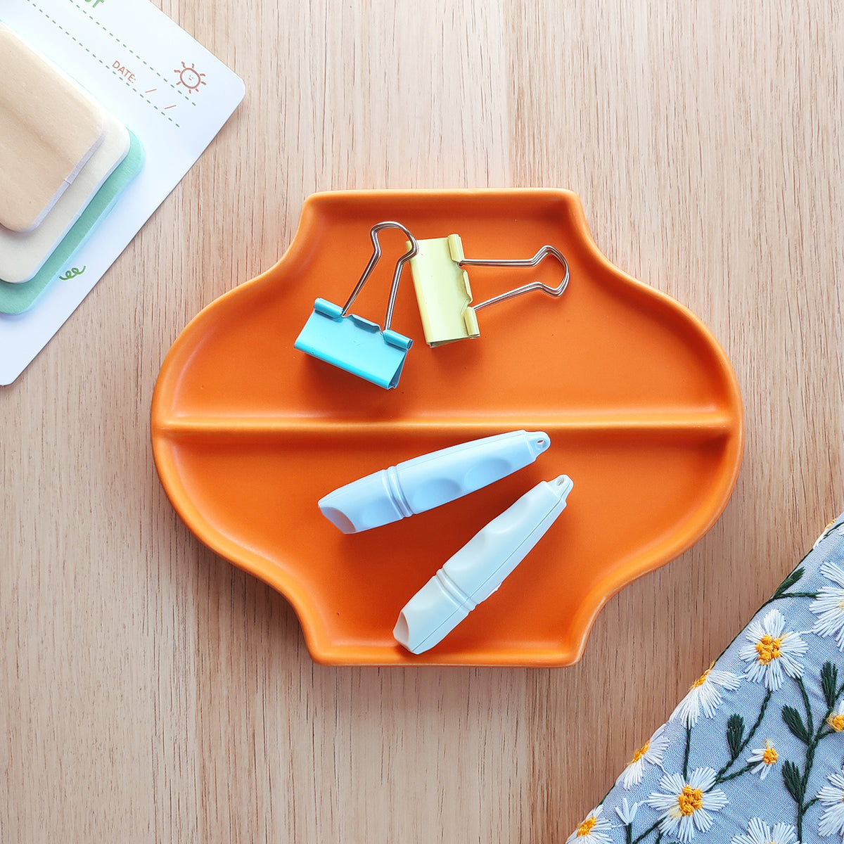 Vassoio Jewe, in ceramica, arancione, vista dall'alto, su scrivania in legno, quaderno e post-it, BECCA